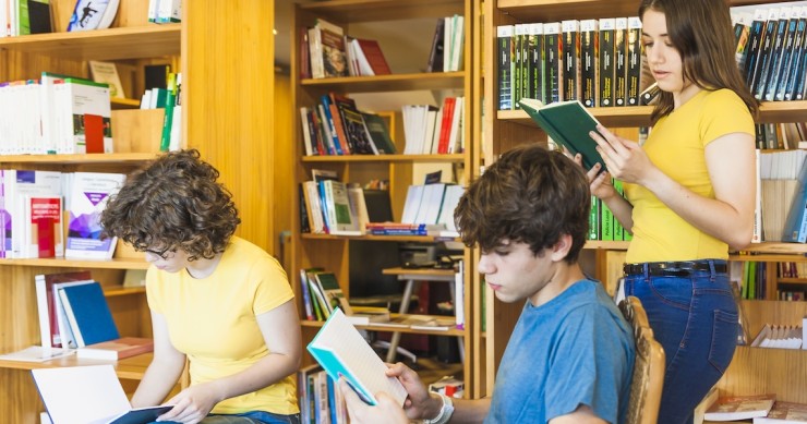 Adolescenti che leggono libri in biblioteca