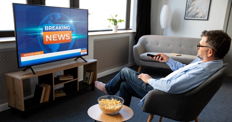 Uomo guarda un notiziario in TV