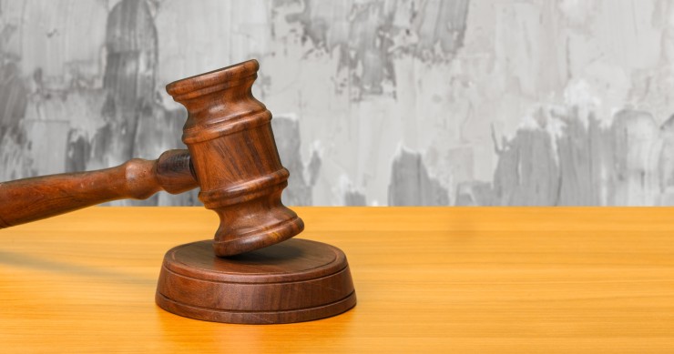 Martelletto di legno con sfondo di parete rovinata che illustra visivamente il classico caso di perizia per danni da infiltrazioni 