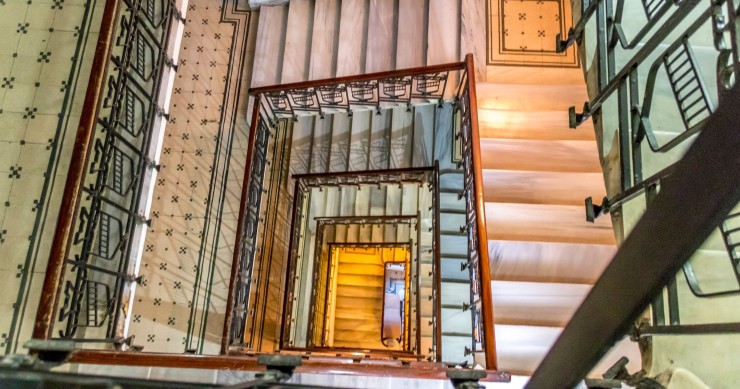 Scalinata a chiocciola con corrimano intricati e pavimentazione decorata