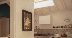 Nella nuova cucina, i soffitti in compensato dialogano con le pareti in mattoni imbiancate della casa originale
