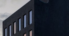 La facciata è caratterizzata da una griglia di finestre strette e verticali, una delle quali ha la forma di un arco rovesciato
