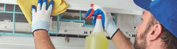 Tecnico in guanti gialli pulisce il condizionatore