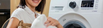 donna che toglie panni dalla lavatrice 