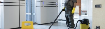 Un operatore delle pulizie che lava l’androne di un palazzo