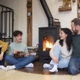 Famiglia che si ritrova insieme vicino alla stufa per riscaldarsi