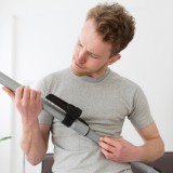 Un uomo con in mano un'aspirapolvere