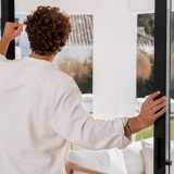 Uomo davanti a una porta-finestra aperta