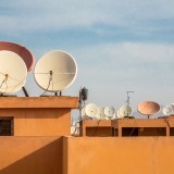 Parabola su balcone appartamento, facciata condominio con parabola