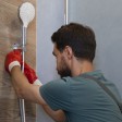 Un idraulico al lavoro su una doccia