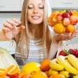 donna davanti a tavolo pieno di frutta 