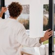 Uomo davanti a una porta-finestra aperta